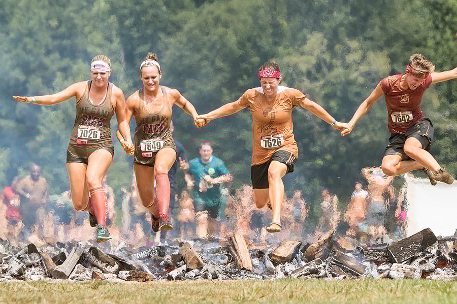 bigstock-Women-Hurdle-Burning-Logs-Toge-116567393